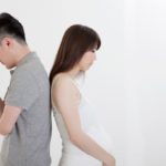 0_Young-man-and-pregnant-woman-standing-with-back-to-back