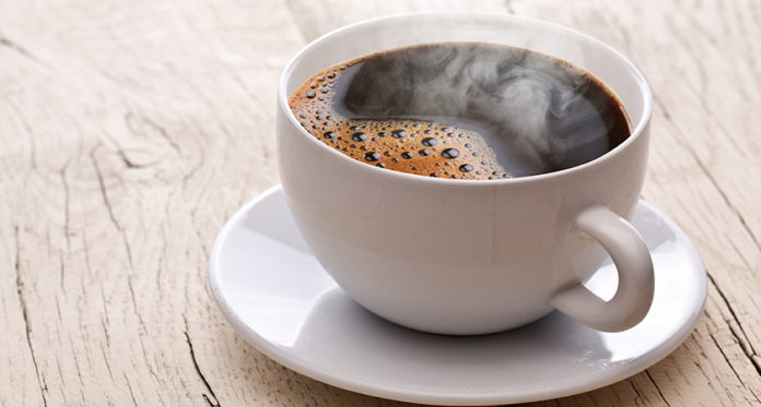 Cup of hot coffee on an old wooden table.